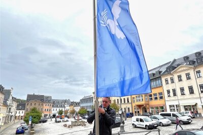 Reichenbach: OB hisst Friedensfahne vorm Rathaus - Oberbürgermeister Henry Ruß hisst die Fahne mit der Friedenstaube vorm Rathaus.