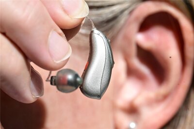 Reichenbach: Schlechtes Hören erhöht das Risiko für Demenz - Eine Frau hält ein Hörgerät vor ihr Ohr.