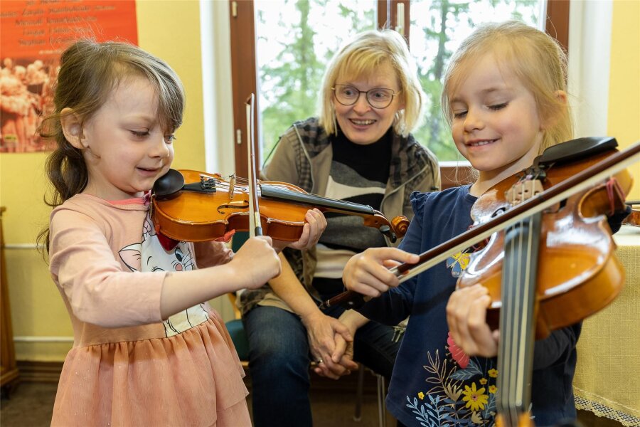 Reichenbacher Kinder probieren sich an Instrumenten aus - Anna-Lena Schneppe (4) und Nora Löwe (5) probieren sich an Geige und Bratsche aus. Geigenlehrerin Beate Seidel hilft dabei.