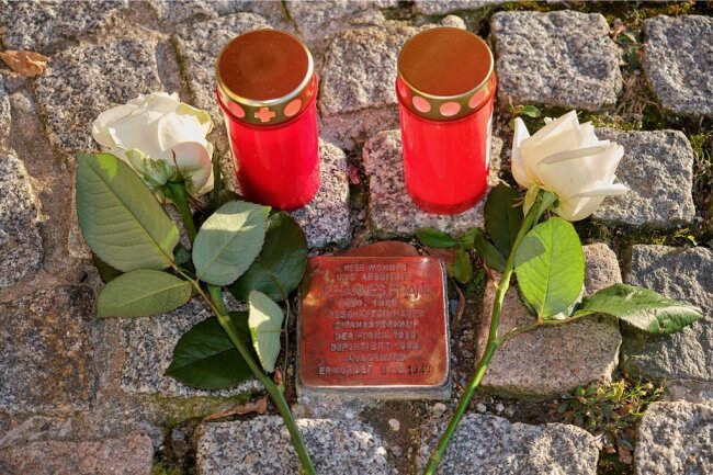 Rosen und Grablichter am Stolperstein für Johannes Frank am Markt 20 in Reichenbach. Er wurde 1943 im KZ Auschwitz ermordet. 