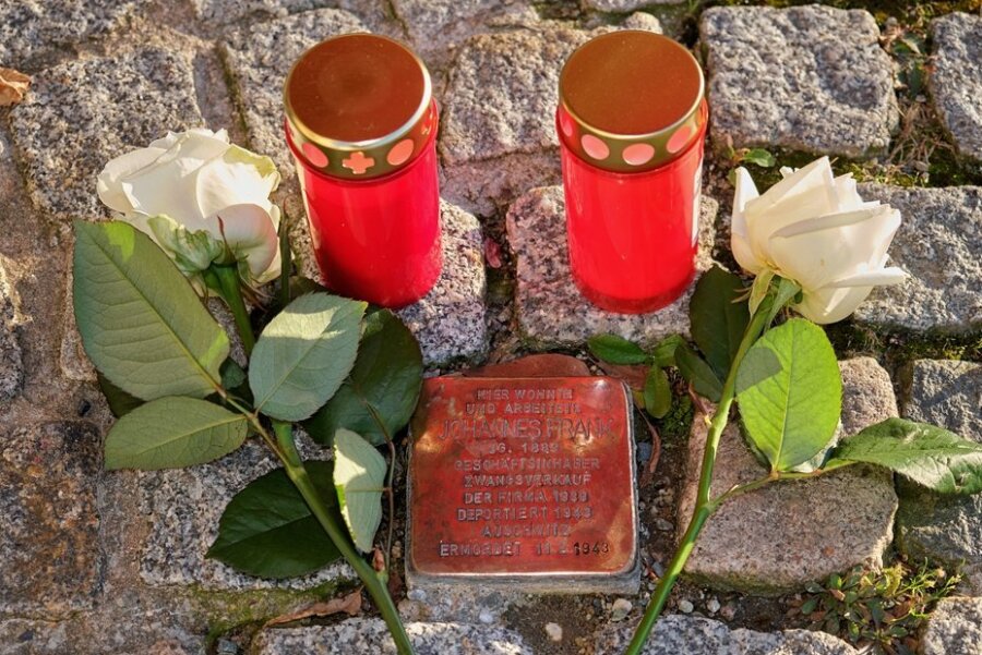 Rosen und Grablichter am Stolperstein für Johannes Frank am Markt 20 in Reichenbach. Er wurde 1943 im KZ Auschwitz ermordet. 