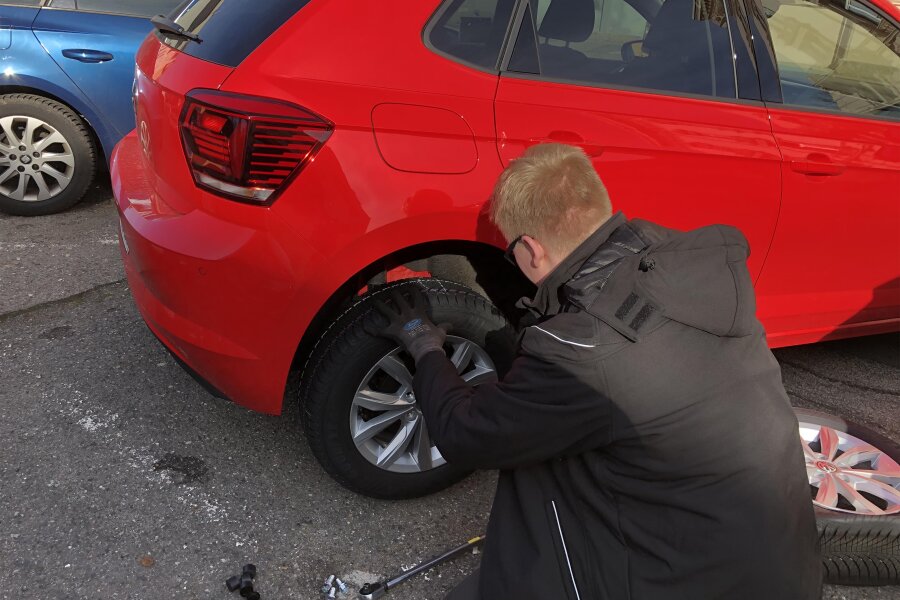 Reifen an 54 Autos in Zwickau zerstochen - Ein Autofahrer in der Saarstraße beim Wechseln eines zerstochenen Reifens.