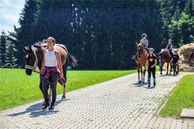 Reiterferien im Erzgebirge: Kinder üben in Schönheide eine Woche lang den Umgang mit Pferden - Nicole Dietrich geht mit Casanova voran, wenn die Kinder in die Umgebung von Schönheide in den Wald ausreiten. Jedes Pferd wird dabei zur Sicherheit geführt.