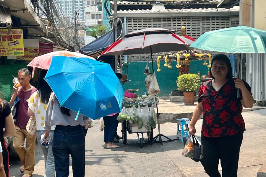 Rekord-Hitze in Thailand fordert mehr als 60 Tote - Menschen schützen sich in Bangkok mit Schirmen vor der extremen Hitze und vor der Sonne.