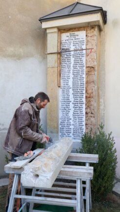 Steinmetz Rolf Schreckenbach bereitet eine Sandsteinsäule für den Einbau vor. Sie begrenzt auf der rechten Seite die Marmorplatte mit den 102 Namen der gefallenen Soldaten aus Callnberg. 