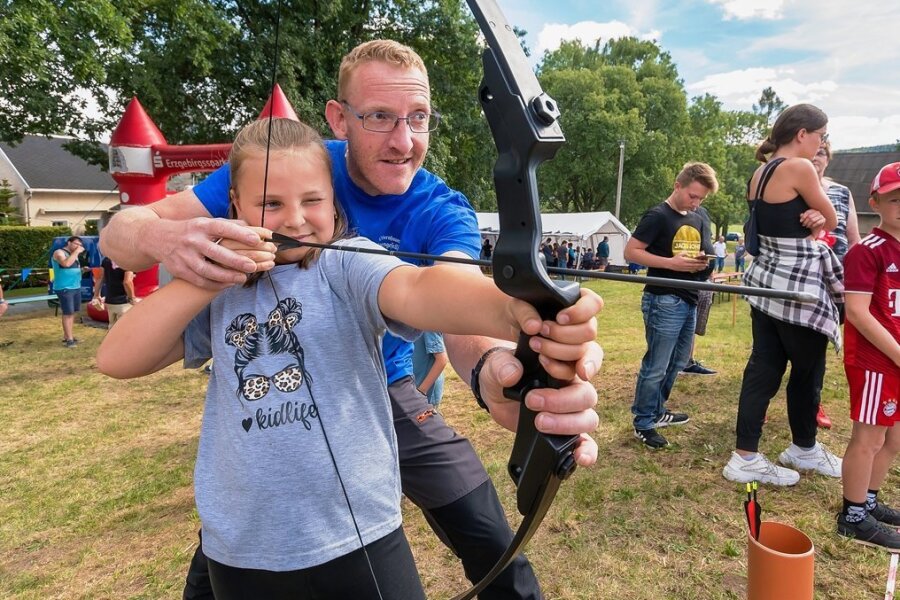 Reukersdorfer feiern Dorffest - Noemi Schmidt lässt sich von Markus May von der Olbernhauer Schützengesellschaft beim Bogenschießen helfen.