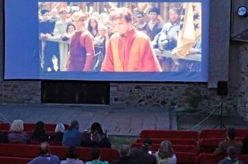 Ritterfilm vor historischer Kulisse - Knapp 70 Besucher nahmen auf Sitzbänken mit roten Decken Platz, um den Film "Ritter aus Leidenschaft" zu sehen. 