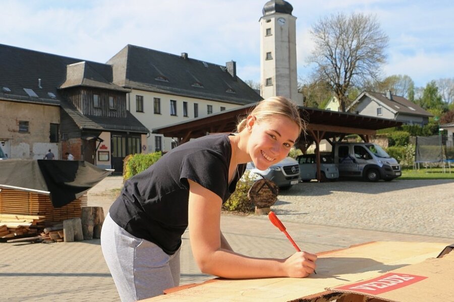 Rößnitz putzt sich fürs Ortsjubiläum heraus - Emma Bromnitz beschriftet die Wegweiser fürs Fest. Es sind lange Baumscheiben aus Kiefer. Die Schrift soll von der Tischlerei im Ort ausgefräst werden.