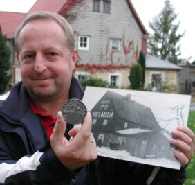 Rosenanbau hat bei Helmichs 80-jährige Tradition - 
              <p class="artikelinhalt">Hans-Peter Helmich mit einem alten Bild vom Haus auf dem Gelände sowie einer Medaille, die sein Großvater für seine Rosenzucht erhielt. </p>
            