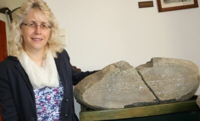 Rothenacker gedenkt dem gelehrten Bauern - Die Reuther Pfarrerin Sabine Stepper zeigt den Stein mit dem Bibelspruch. Er stammt vom Wohnhaus des gelehrten Bauern. 