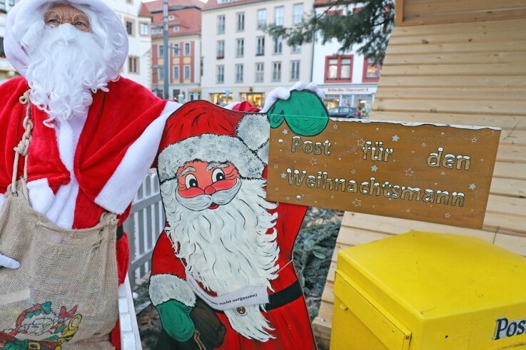 Freibergs Weihnachtsmann mit seinem hölzernen Abbild an der Krippe auf dem Obermarkt.