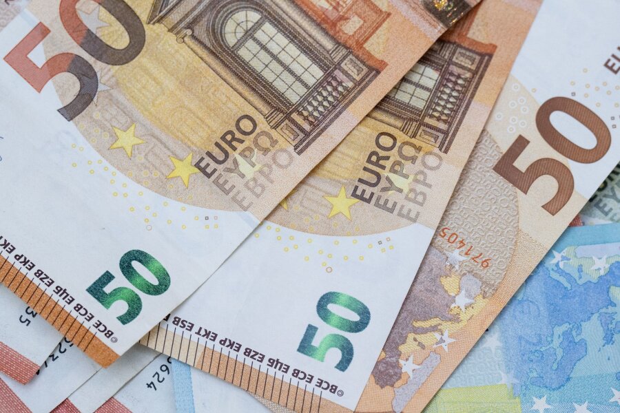 Sachsen mit höherem Monatseinkommen als Saarland - Zahlreiche Euro-Banknoten liegen auf einem Tisch.