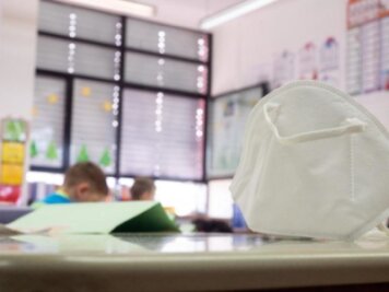Sachsen plant Wegfall der Maskenpflicht im Unterricht ab 8. November - Eine FFP2-Maske liegt in einer Grundschule auf einem Tisch. 