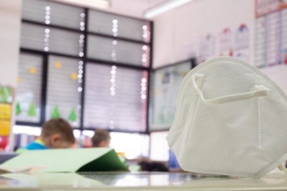 Sachsen plant Wegfall der Maskenpflicht im Unterricht ab 8. November - Eine FFP2-Maske liegt in einer Grundschule auf einem Tisch. 