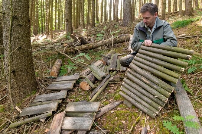 Revierleiter Thomas Köhler vor den Überresten einer aus Holz gebauten Schanze. 
