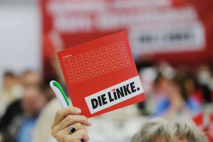Eine Delegierte des Landesparteitages der Partei Die Linke in Sachsen hält ihre Stimmkarte in die Höhe. 