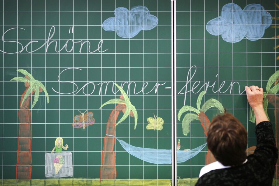 Sachsens Schülerinnen und Schüler gehen in die Sommerferien - Eine Lehrerin schreibt "Schöne Sommer-ferien" an eine Tafel in einer Grundschule.