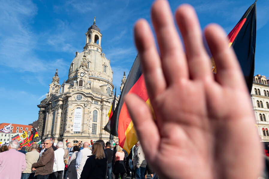 Sachsens Verfassungsschutz stuft Pegida als extremistisch ein - Dresden: Ein Teilnehmer einer Kundgebung von Pegida auf dem Altmarkt hält seine Hand vor die Kamera des Fotografen.
