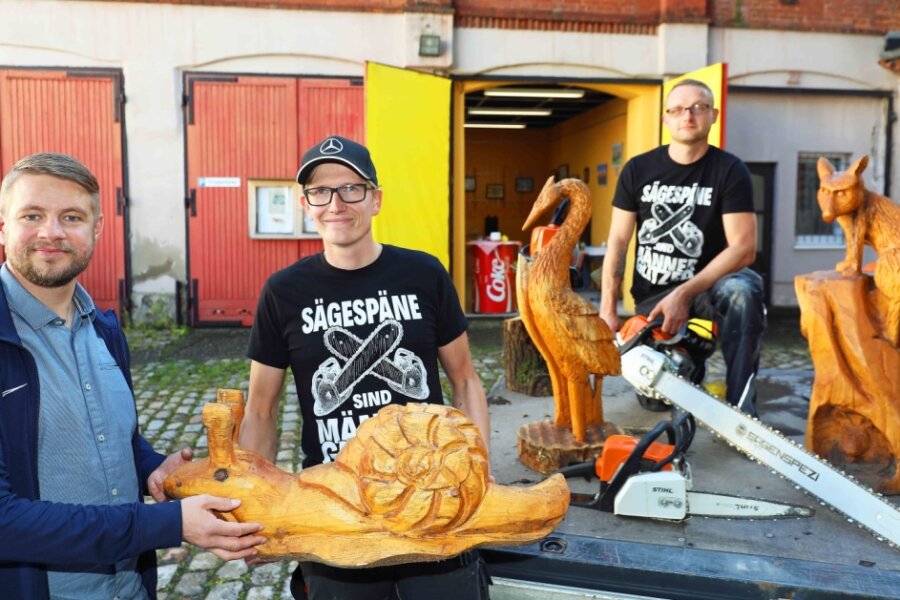 Thomas Sprotte, Vorsitzender des Jugendclub-Fördervereins, mit den Kettensägen-Hobbykünstlern Jean-Philipp Russel und Michael Germuhl. Ihre Werke, meist Tierfiguren, sind zwischen 30 Zentimeter und zwei Meter groß.