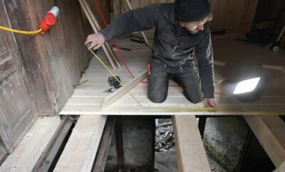 Sägewerk bekommt neuen Zwischenbau - Zimmerermeister Arndt Baltzer aus Brand-Erbisdorf verlegt gerade die Dielung im Überbau über dem Wassergraben.