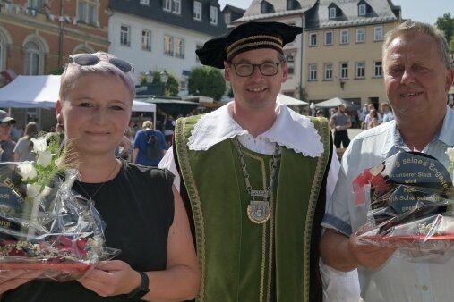 Salzmarkt in Lößnitz wartet 2022 mit Besonderheit auf - Christin Georgi und Frank Scharschmidt (rechts) wurden von Bürgermeister Alexander Troll (Mitte) mit dem Kniebügel ausgezeichnet. 