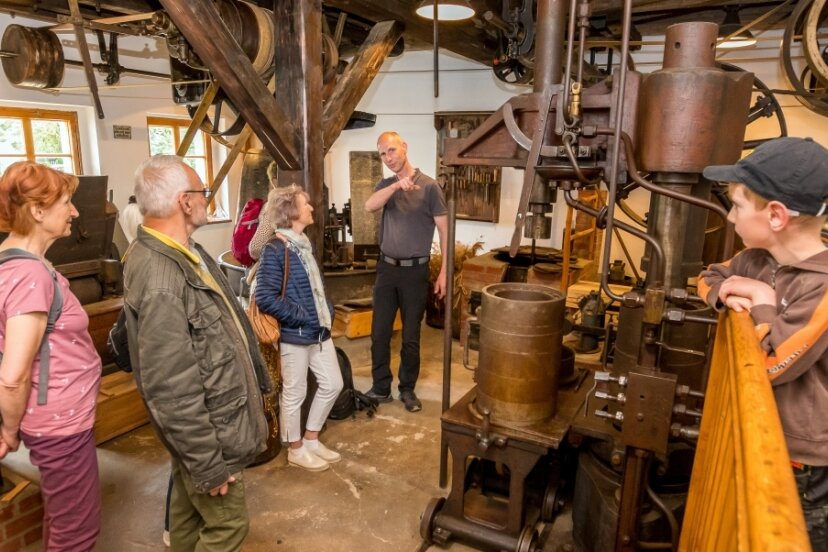 Marco Oettel (Bildmitte), ein Mitglied des Pockauer Heimat- und Mühlenvereins, zeigte Besuchern am Samstag in der sogenannten neuen Mühle die Technik der Ölgewinnung des 20. Jahrhunderts. 