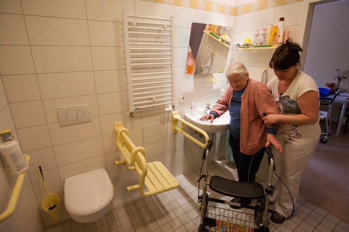Sanierung des Pflegeheims nach drei Jahren abgeschlossen - Schwester Marion Perach hilft Bewohnerin Erika Pagel in das neue Badezimmer. Es ist Teil einer größeren Investition im Bonavita-Pflegeheim.