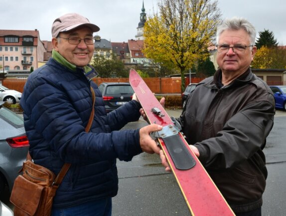 Die ehemaligen Skispringer Gotthard Lehn (l.) und Andreas Nickel, die hier einen alten Sprung-Ski zeigen, wollen mit einer Tafel an die ehemalige Schanze in Schönborn-Dreiwerden erinnern. Sie wird am Samstag, 14 Uhr, eingeweiht.