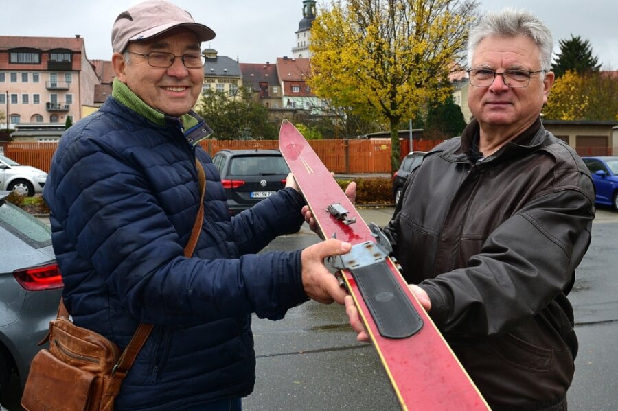 Die ehemaligen Skispringer Gotthard Lehn (l.) und Andreas Nickel, die hier einen alten Sprung-Ski zeigen, wollen mit einer Tafel an die ehemalige Schanze in Schönborn-Dreiwerden erinnern. Sie wird am Samstag, 14 Uhr, eingeweiht.