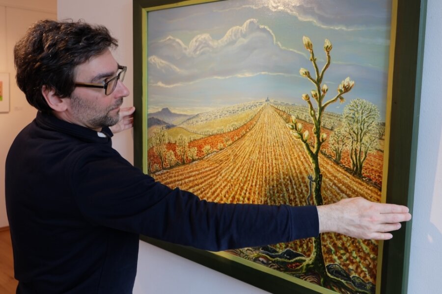 Auf dem Foto präsentiert Galerieleiter Alexander Stoll ein Ölgemälde von Werner Franz