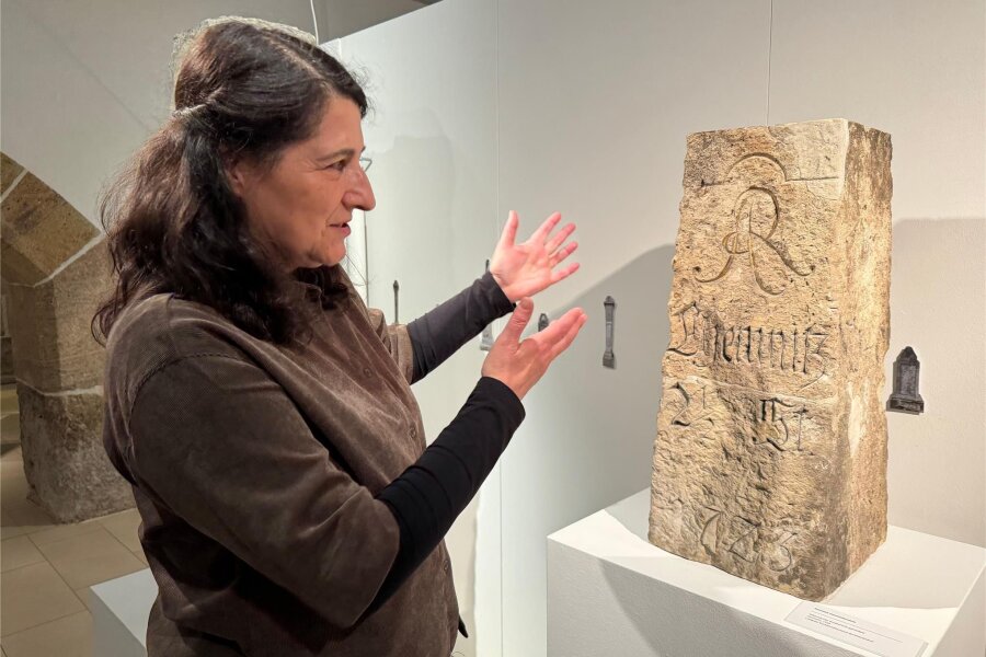 Schau zu 300 Jahre Postmeilensäulen: Als Steinsäulen Reisenden den Weg wiesen - Andrea Kramarczyk, Kuratorin der Ausstellung, erklärt Inschriften eines erhaltenen Fragments einer Ganzmeilensäule.