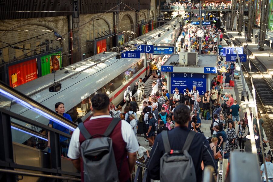 Schimpfen und fahren - Menschen wieder mehr im Zug unterwegs - An Bahnsteigen für den Fernverkehr des Hamburger Hauptbahnhofs stehen zahlreiche Fahrgäste. Die Menschen in Deutschland fahren nach einer Statistik wieder mehr Zug.
