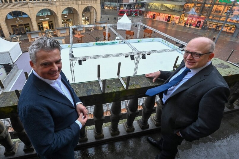 Oberbürgermeister Sven Schulze (SPD, rechts) und Ringo Lottig, Vorstand der Chemnitzer Siedlungsgemeinschaft, beim Blick vom Rathausbalkon auf die Kunststoff-Eisbahn, die auf dem Neumarkt aufgebaut wurde. Eröffnet wird der bis 6. März angesetzte "Eiszauber" am Freitagmittag. 