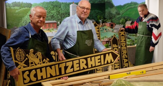 Schnitzereien, die nicht aus Holz sind - Peter Teichmannn, Jürgen Scheibner und Bernd Steinert (von links) mit den neuen Wegweisern. Aus Holz sind sie nur scheinbar. 
