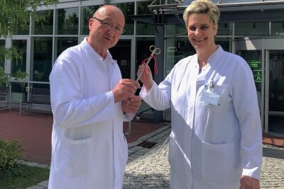 Schöneck: Chefarzt der Chirurgie gibt Schere weiter - Dieter Haugk reicht symbolisch seine "Lieblingsschere" an die neue Chefärztin Dr. Kathrin Tröger weiter.