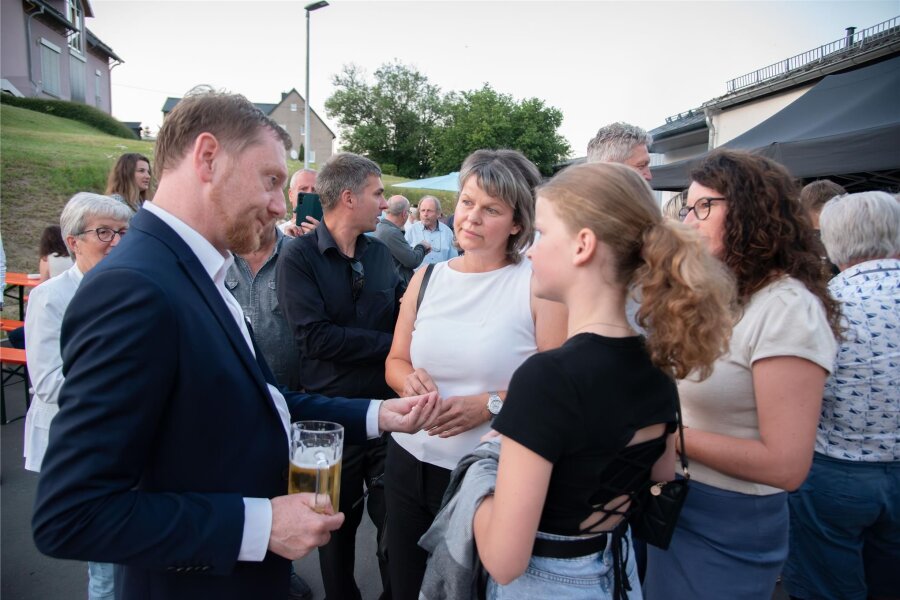 Schönfelser trinken Bier mit Ministerpräsident Kretschmer – wie kam es dazu? - Ministerpräsident Michael Kretschmer mit Bürgern in Triebel beim Bier. Rechts neben ihm steht Chris Stegert aus Schönfels.