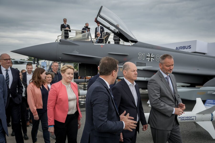 Scholz fordert mehr Zusammenarbeit bei Rüstungsprojekten - Bundeskanzler Olaf Scholz (SPD,2.v.r) auf der Internationalen Luft- und Raumfahrtausstellung (ILA) vor einem mit einem Taurus-Marschflugkörper bestückten Eurofighter.