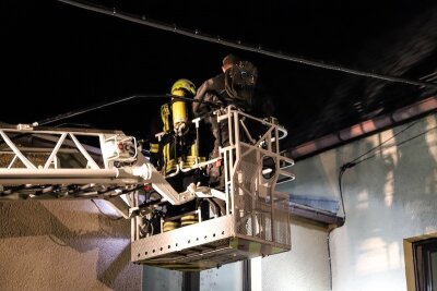 Schornsteinbrand in Albernau beschäftigt Feuerwehren über Stunden - Feuerwehrmann und Schornsteinfeger im Drehleiterkorb der Feuerwehr Aue, kurz vor der Reinigung des in Brand geratenen Schornsteins.