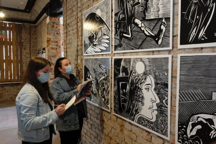 Celina Müller (links) und Josephine Zimmermann betrachten Grafik-Repliken des Künstlers Wolfgang Mattheuer im Haus Solbrigplatz 1.
