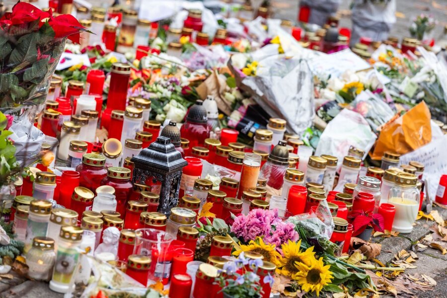 Schüsse an Schule: 15-Jähriger wegen Mordes vor Gericht - Kerzen und Blumen liegen vor dem Eingang der Waldbachschule.