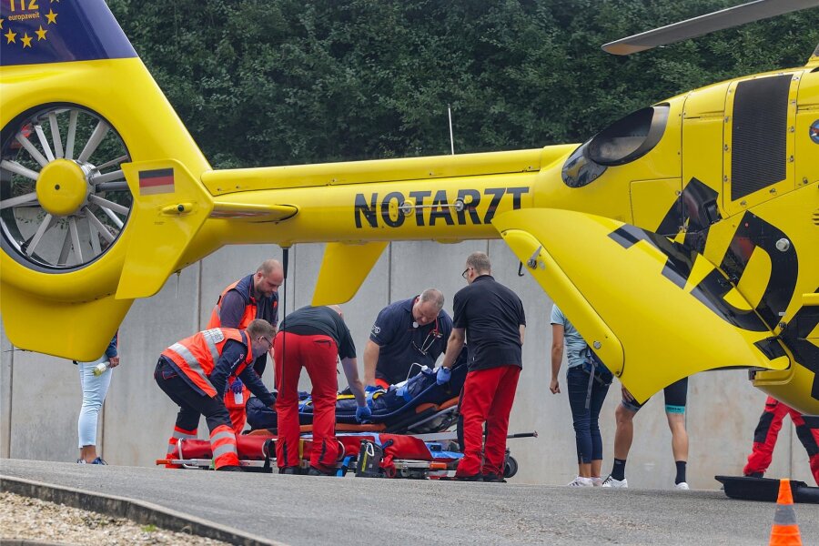 Schwerer Unfall überschattet Sachsenring-Radrennen - Rettungskräfte kümmern sich um einen schwer verletzten Rennradfahrer, der auf dem Sachsenring gestürzt war.