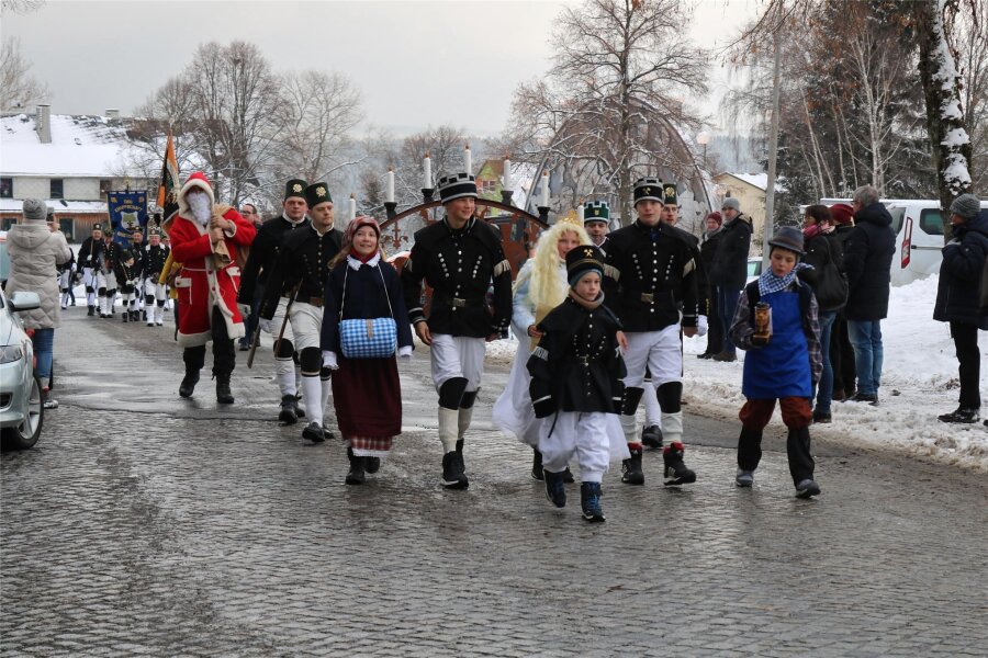 Schwibbogenfest in Johanngeorgenstadt startet: Das erwartet Besucher - Bergaufzug zum Schwibbogenfest in Johanngeorgenstadt: Auch die Schwibbogen-Figuren und der Weihnachtsmann sind dabei.