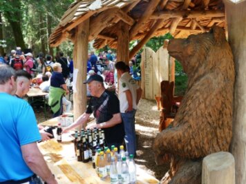 Sehnsucht und Neugierde sorgen für großen Andrang im Wald - In der neuen urigen Rasthütte, die als Getränkestand diente, hatten die Helfer des Heimatvereins einen großen Bären an ihrer Seite. 