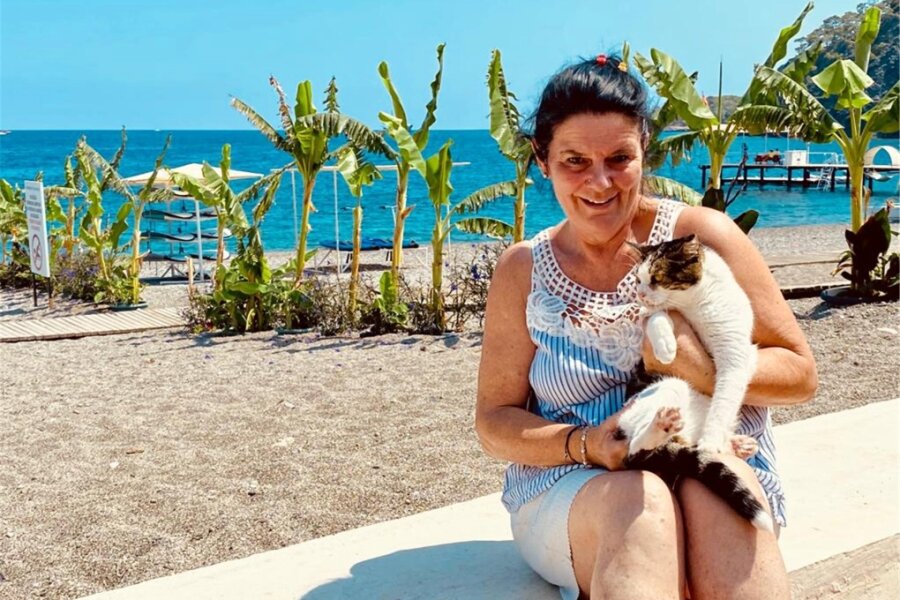 Seit 24 Jahren in der Türkei: Eine Auswanderin aus Chemnitz und ihre Liebe zu Katzen - Carola Graichen am Strand mit dem Hotelkater Eddy. Eddy ist einer von 40 Hotelkatzen, um die sich Carola Graichen in ihren Pausen oder vor und nach der Arbeit kümmert.