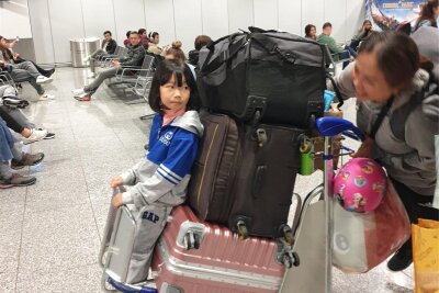 Siebenjährige aus Vietnam im Erzgebirge angekommen: Der lange Weg der Anh Thu Le - Endlich angekommen: Anh Thu Le (M.) auf dem Flughafen Frankfurt am Main.
