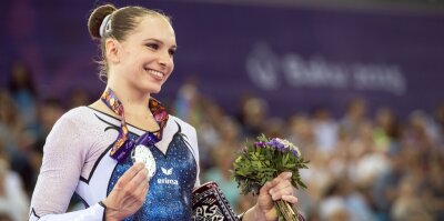 Silber, das wie Gold glänzt - Sophie Scheder zeigt in Baku stolz ihre im Stufenbarren-Finale erturnte Silbermedaille in die Kameras.