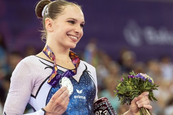 Silber, das wie Gold glänzt - Sophie Scheder zeigt in Baku stolz ihre im Stufenbarren-Finale erturnte Silbermedaille in die Kameras.