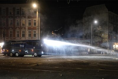 Silvesternacht in Leipzig: Polizei setzt Wasserwerfer gegen brennende Barrikaden ein - Ein Wasserwerfer der Polizei auf einer Straße im Stadtteil Connewitz. In der Neujahrsnacht ist es dort zu kleineren Ausschreitungen gekommen.