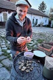 Sind Schnecken bald das bessere Fleisch? - Schneckenzüchter Andreas Gugumuck streut Gewürze in die Schneckenhäuser, bevor sie auf den Grill kommen.