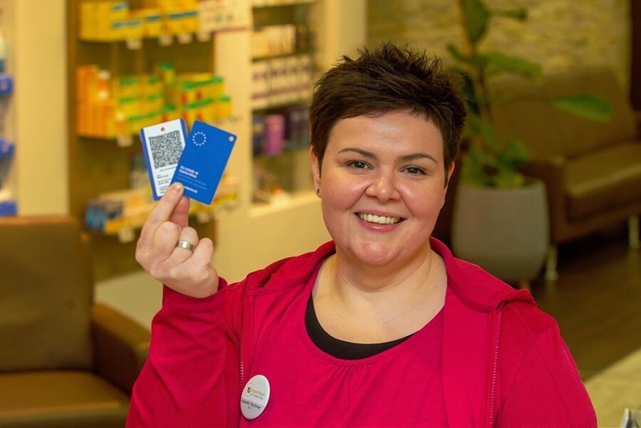 So kommt der Impfnachweis im Scheckkartenformat in Plauen an - Vorne blau, hinten der QR-Code: Isabelle Täschner von der Plauener Apotheke am Löwel-Platz zeigt, wie die Immunkarte aussieht. 